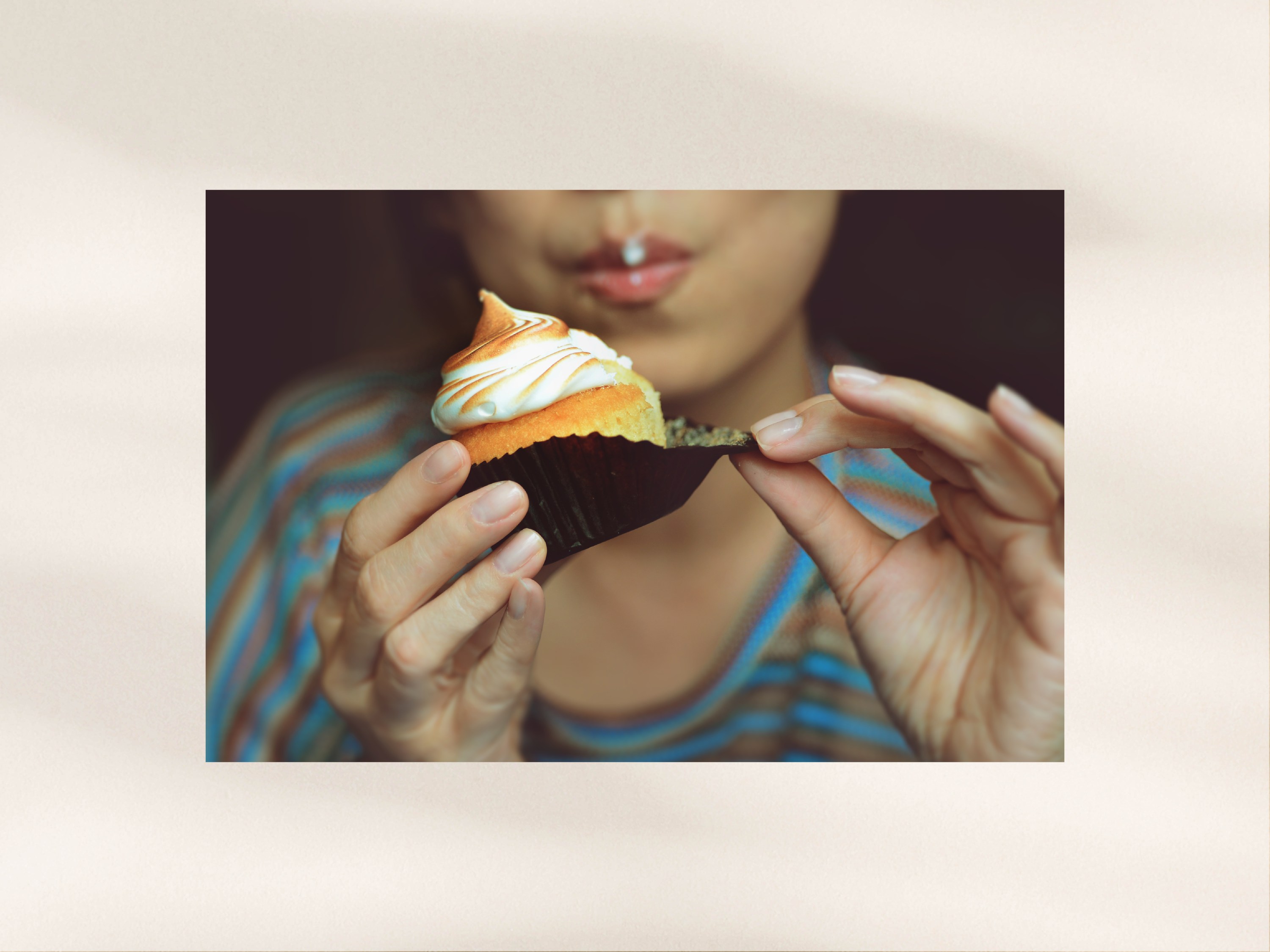 Young woman eating a cupcake.